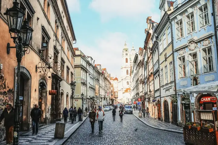 A cobbled old-town street with a church tower in the distance — Golden Day 200